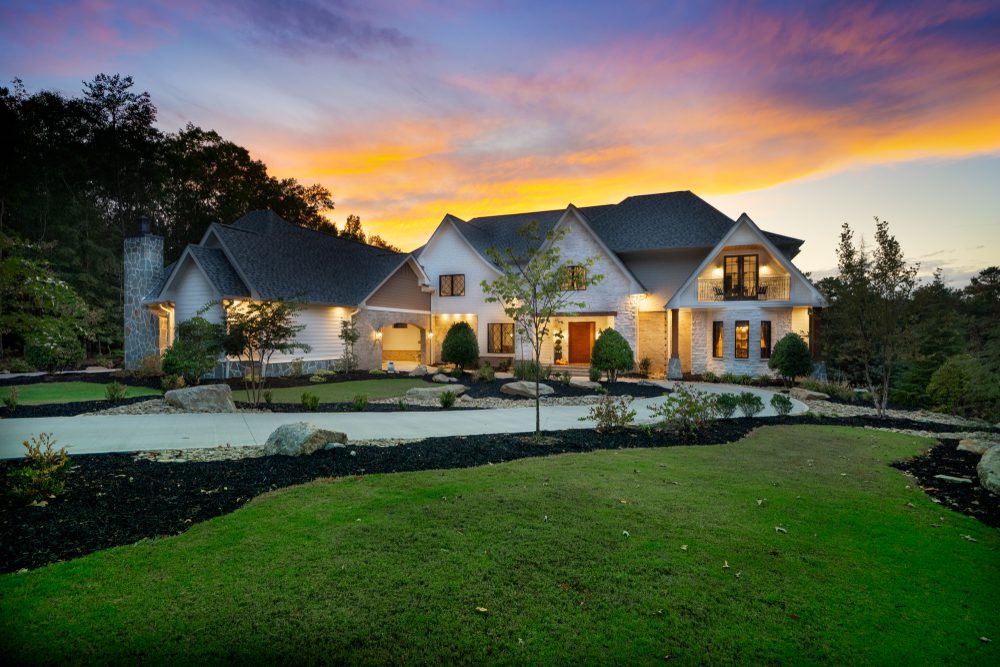 A large white house with a lush green lawn.